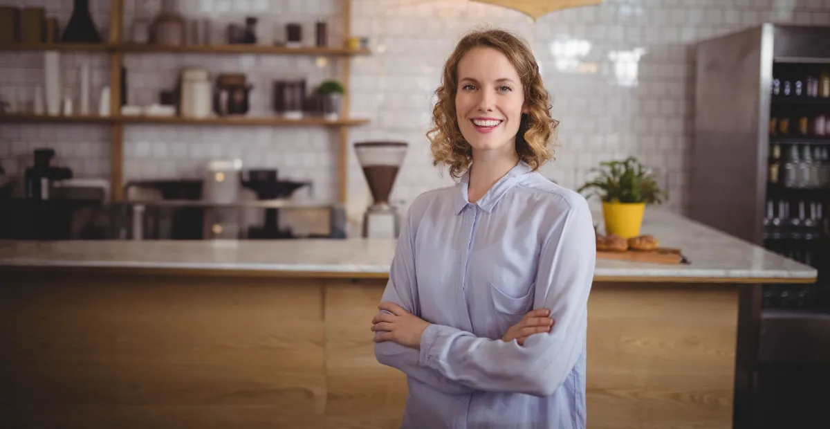 Autónoma de pie en su cafetería, negocio que necesita llevar su contabilidad al día